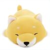 Un petit chien jaune en peluche dormant sur le ventre.