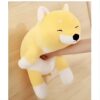 Une peluche de chien jaune et blanc souriant, tenant un bras humain.