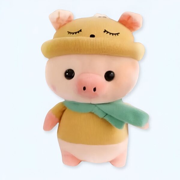 Une peluche de cochon rose portant un bonnet jaune et une écharpe verte.