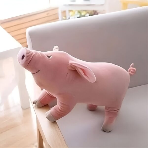 Un gros cochon en peluche rose assis sur un fauteuil blanc.