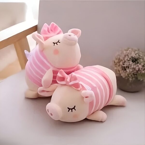 Deux adorables cochons en peluche, l'un portant un nœud rose et l'autre un nœud rose et des rayures roses.