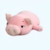 peluche-cochon-rose-assoupi-cadeau-enfant-1a Un coussin en forme de cochon rose allongé sur le ventre.