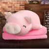 Gros coussin rose en forme de cochon avec un sourire sur un fond en bois.