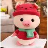 peluche-cochon-rouge-habille-bonnet-et-echarpe-2a Un cochon en peluche portant un chapeau rouge et une écharpe verte.