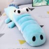 Grande peluche en forme de crocodile bleu, avec de grands yeux blancs et une bouche ouverte. Parfait pour les câlins et la décoration de la chambre d'enfant.