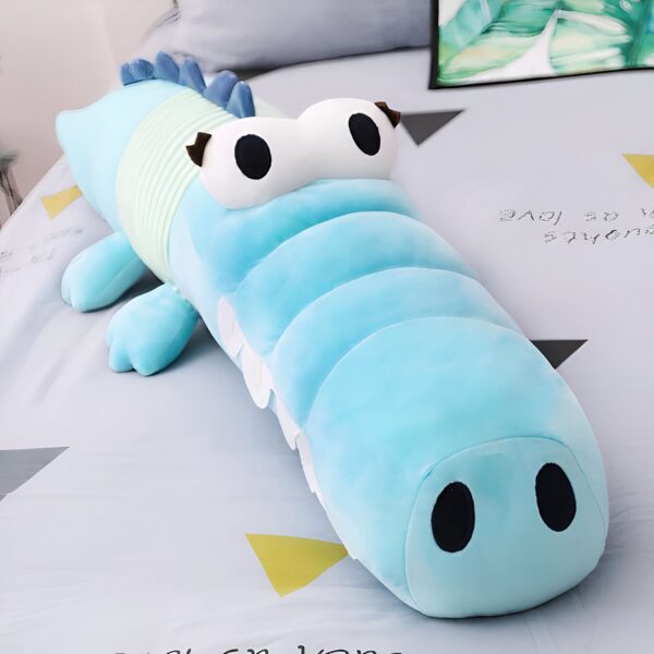 Grande peluche en forme de crocodile bleu, avec de grands yeux blancs et une bouche ouverte. Parfait pour les câlins et la décoration de la chambre d'enfant.