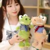 peluche-crocodile-bebe-marin-jouet-doux-enfant-2a Une jeune femme tenant deux peluches de crocodile, un vert et un beige, portant des vêtements rayés.