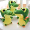 Trois crocodiles en peluche vert et jaune avec de grands yeux noirs.