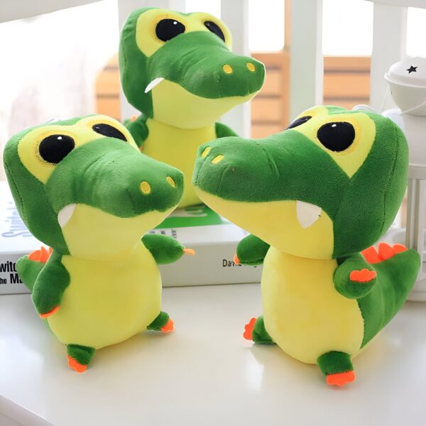Trois crocodiles en peluche vert et jaune avec de grands yeux noirs.