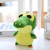 Une peluche de crocodile vert et jaune avec de grands yeux noirs.
