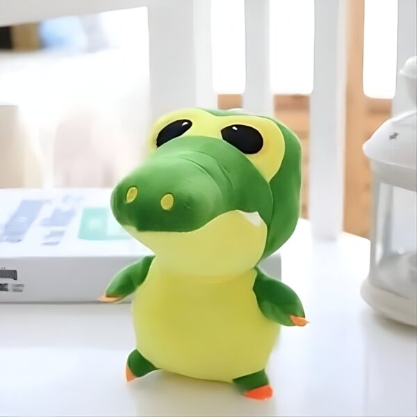 Une peluche de crocodile vert et jaune avec de grands yeux noirs.