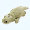 Gros crocodile en peluche vert couché sur le ventre.