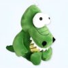 peluche-crocodile-rigolot-jouet-enfant-1a-2 Une peluche verte en forme de crocodile avec de grands yeux blancs et une bouche ouverte montrant des dents.