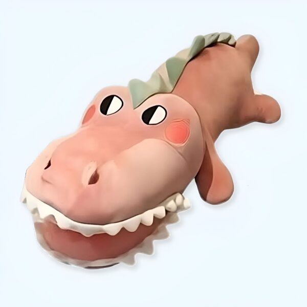 Peluche de dinosaure rose avec des yeux noirs et des dents blanches.