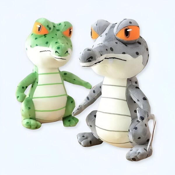Deux crocodiles en peluche, un vert et un gris, avec des yeux orange.
