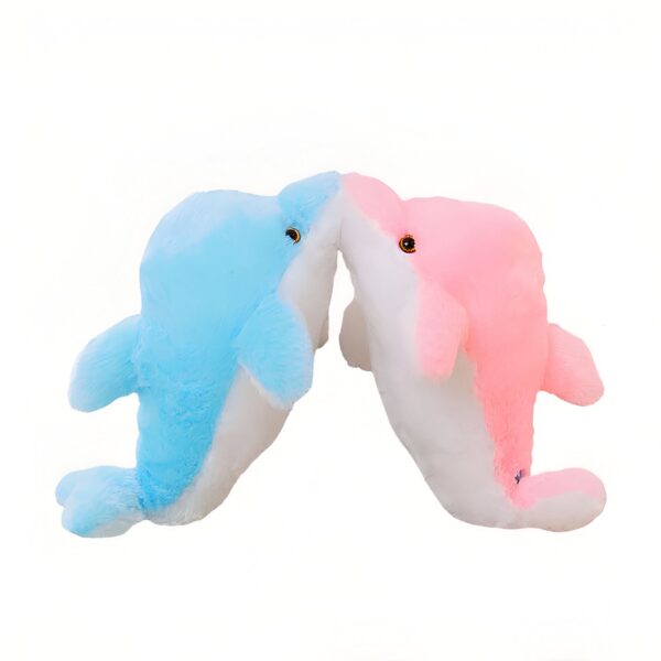 peluche-dauphin-lumineuse-lampe-de-chevet-et-compagnon-de-sommeil-6a Deux dauphins en peluche, un bleu et un rose, se font face et se touchent le nez.