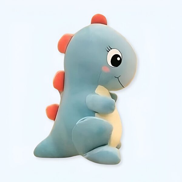 Peluche bleu en forme de dinosaure avec de gros yeux noirs et une petite bouche rose.