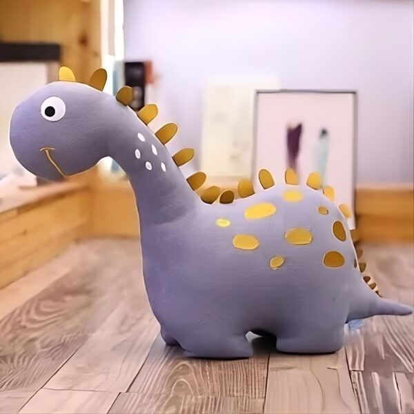 Une peluche de dinosaure gris avec des points jaunes sur le dos.