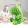 Une peluche de dinosaure vert avec des yeux fermés et une note de musique sur le pied.