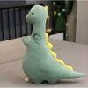 Peluche de dinosaure vert avec des détails jaunes sur le dos et une couronne noire.