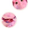 Gros plan sur la tête et la queue d'un adorable dinosaure rose en peluche.