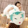 Une jeune femme sourit en tenant une grande peluche blanche avec des détails bleus et des yeux noirs.
