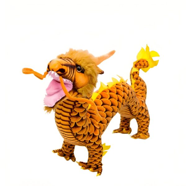 Un dragon en peluche jaune et orange avec des écailles, la bouche ouverte et la langue rose. Il est sur un fond blanc.