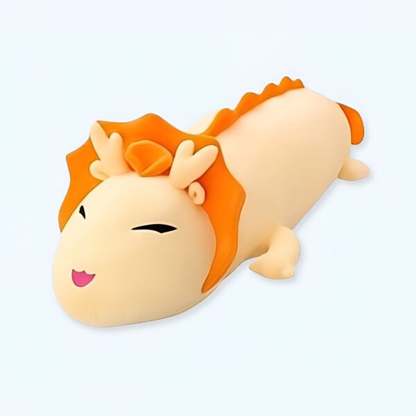 Une peluche en forme de dragon jaune avec des cornes orange.