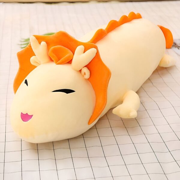 peluche-dragon-de-feu-jouet-doux-et-confortable-pour-enfants-et-adultes-2a-2 Gros coussin en forme de dragon jaune avec des détails orange. Le dragon a un sourire amical et des yeux noirs.