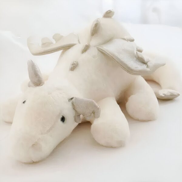 peluche-dragon-volant-blanc-jouet-doux-pour-enfants-1a-4 Un dragon en peluche blanc couché sur le dos, avec ses ailes déployées.