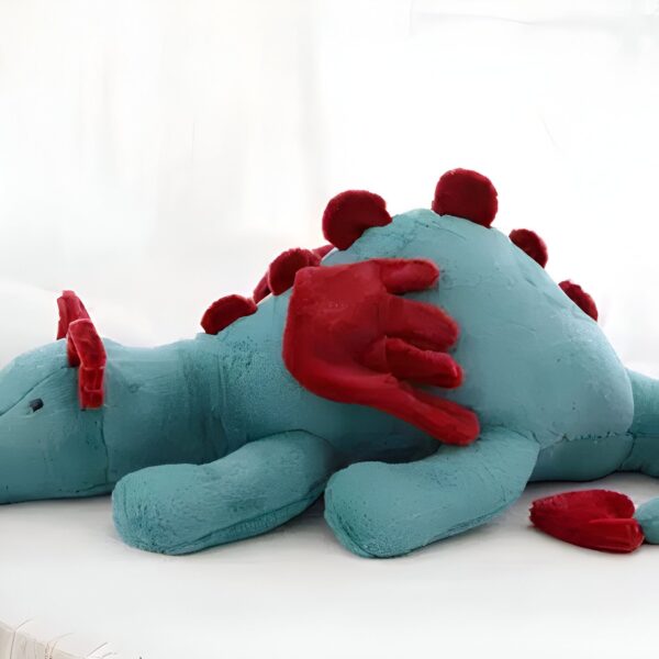 peluche-dragon-volant-bleu-ailes-rouges-1a-4 Gros dinosaure en peluche bleu avec des ailes et des pointes rouges.
