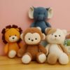 Un éléphant en peluche bleu, un lion en peluche orange, un singe en peluche brun et un chien en peluche blanc et marron.