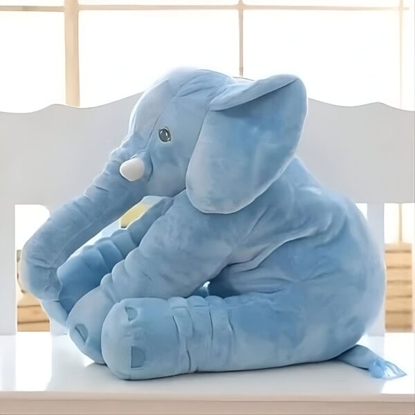 Un éléphant en peluche bleu assis sur un banc blanc.