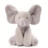 Un éléphant en peluche gris assis avec des oreilles qui bougent. Il a des boutons "Sing" et "Play" sur ses pattes.
