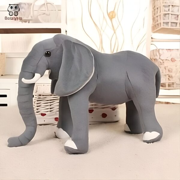 Grande peluche d'éléphant gris avec des détails blancs sur les pieds et les oreilles.