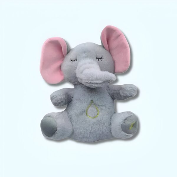 Un éléphant en peluche gris avec de grandes oreilles roses et des yeux fermés. Il a un petit motif vert sur son ventre.