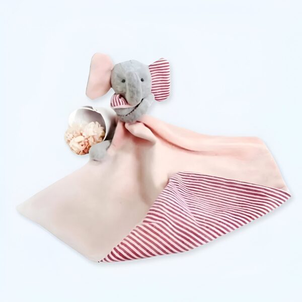 Une couverture rose avec un éléphant en peluche gris à rayures rouges.
