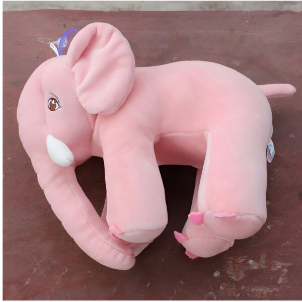 Un éléphant en peluche rose avec de grands yeux bruns, sur un fond en bois.