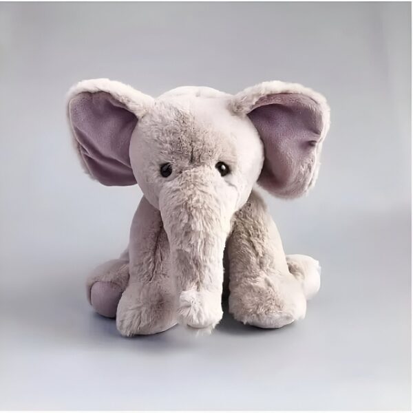 Une peluche d'éléphant gris assis avec de grandes oreilles roses.