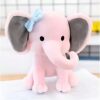 Un éléphant en peluche rose avec un nœud bleu sur l'oreille.