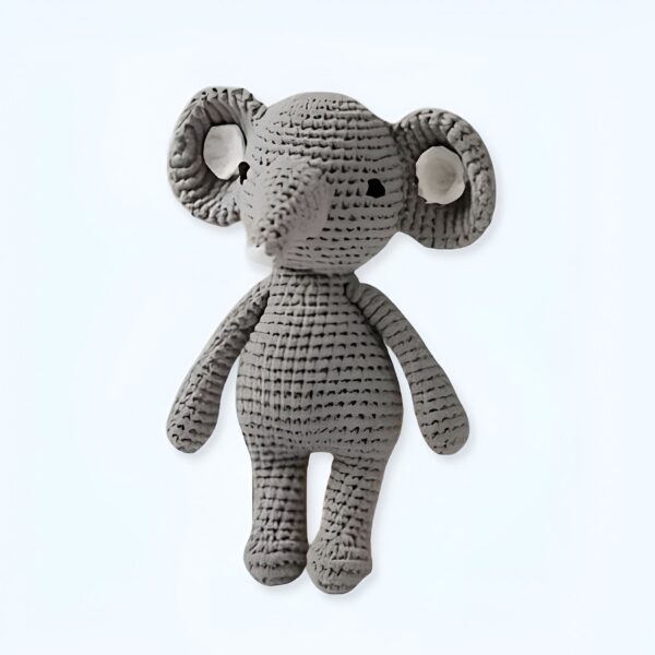 Un éléphant en peluche gris tricoté à la main avec de grandes oreilles et de petits yeux.