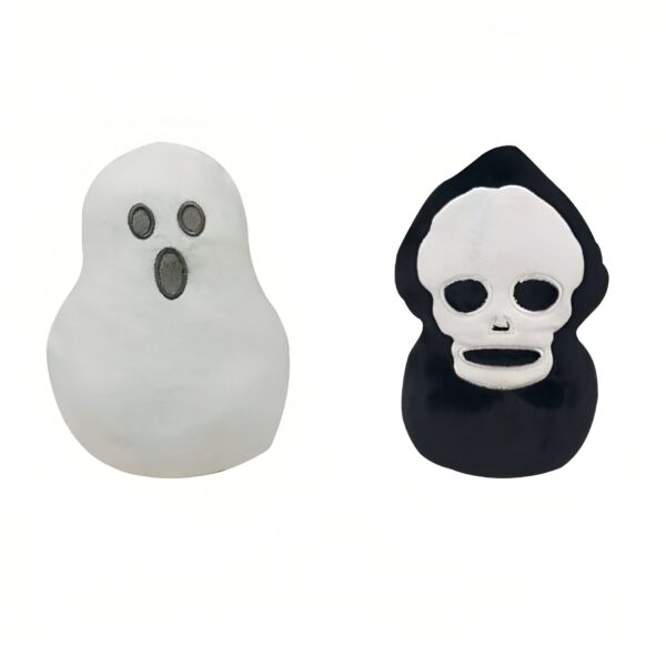 Deux coussins en peluche d'Halloween, l'un en forme de fantôme blanc et l'autre en forme de crâne noir.