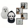 Deux peluches d'Halloween, un fantôme blanc et un crâne noir. Les peluches sont en peluche et ont des yeux et une bouche brodés.