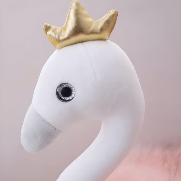 peluche-flamant-rose-princesse-avec-couronne-et-chaussures-dorees-cadeau-enfant-5a Une peluche blanche en forme de flamant rose avec une couronne dorée sur la tête.