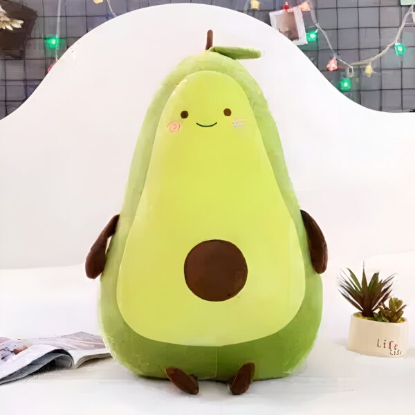 Une peluche en forme d'avocat souriant avec un noyau brun et des petites jambes.