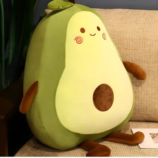 Un oreiller en forme d'avocat souriant avec un noyau brun.