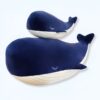 Deux baleines en peluche bleue, l'une sur l'autre, avec des yeux brodés et des rayures blanches.