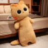 Une peluche de chat beige avec de grands yeux noirs et des moustaches orange debout sur un lit.