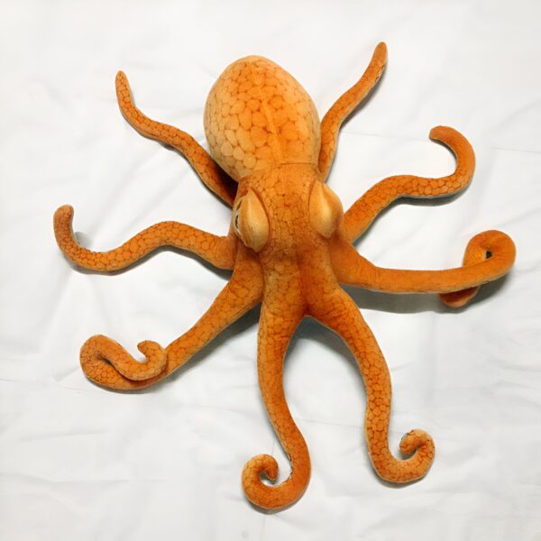 peluche-geante-pieuvre-orange-jouet-doux-enfant-et-adulte-2a-2 Une pieuvre en peluche orange posée sur un fond blanc.
