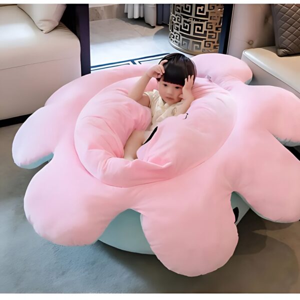 Un jeune enfant assis dans un fauteuil en forme de nuage rose.